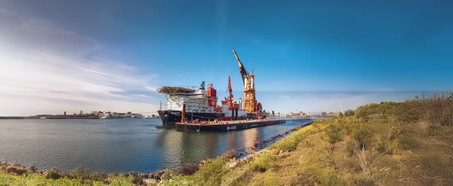 A vessel with heavy lift barge in a waterway