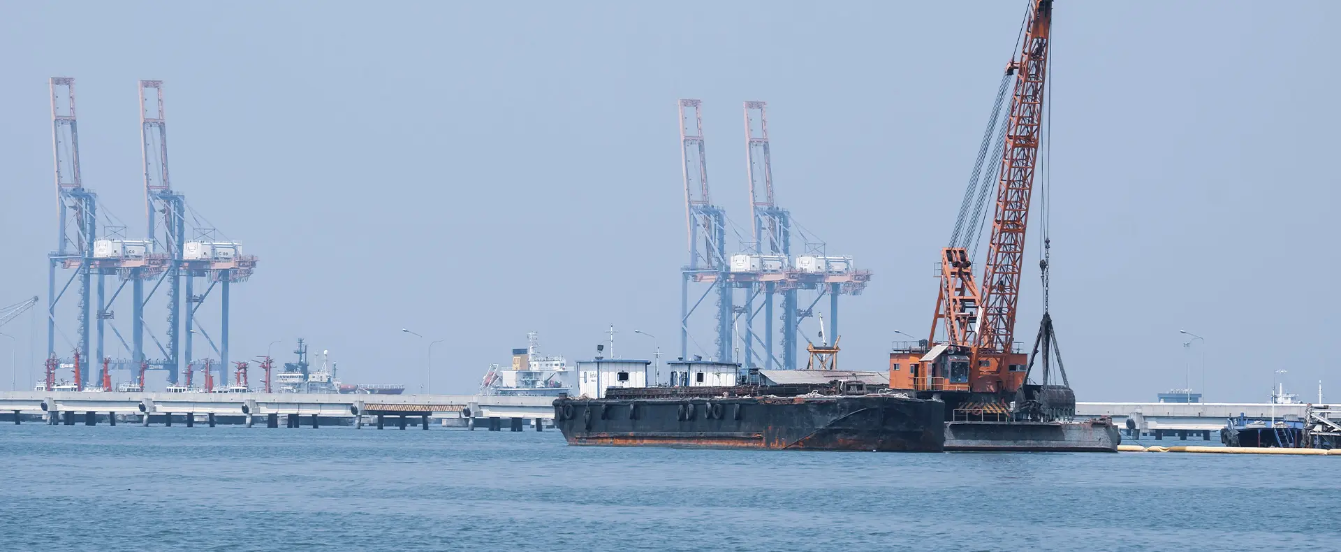 Marine and offshore project Harbor cranes and construction equipment at industrial shipping port with cargo terminals