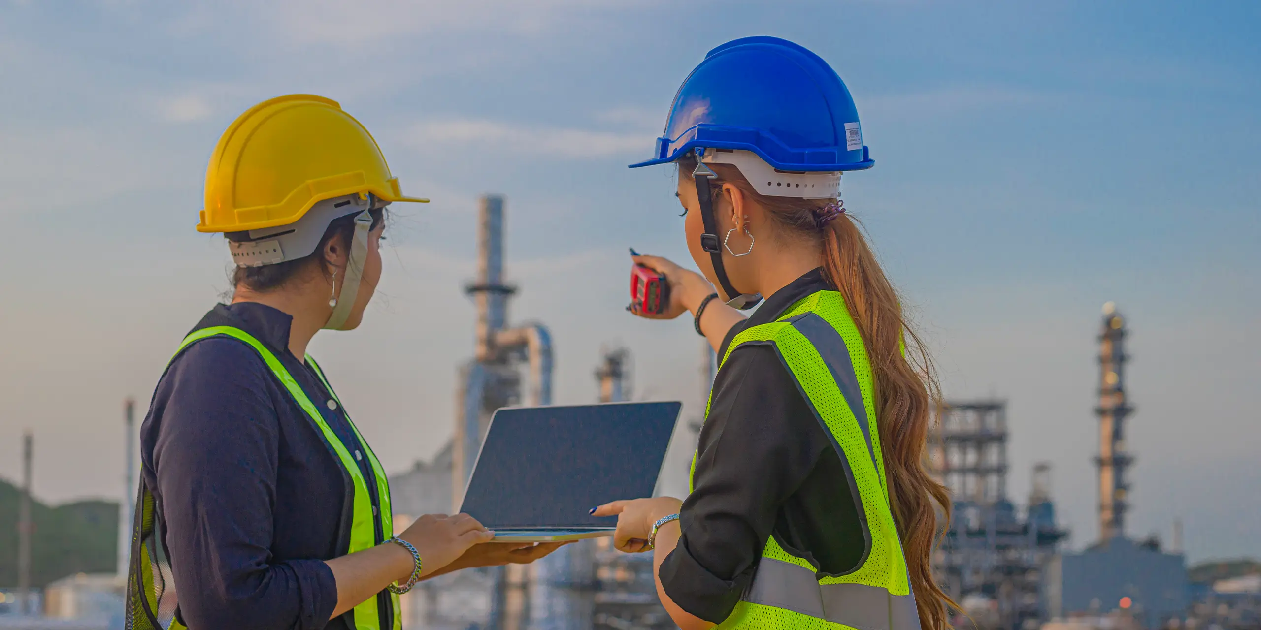 Two field workers using mobile devices during capital project execution to report progress to the office.