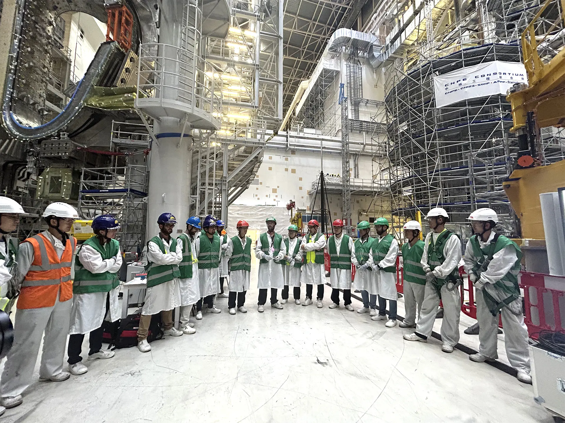 ITER Tokamak Pit Assembly A group of engineers and workers gather in a circle within the massive ITER Tokamak pit during assembly.