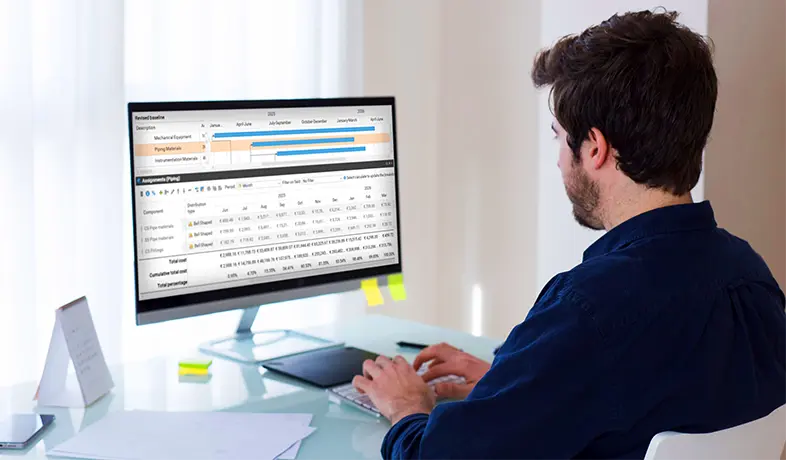 A worker monitoring a time-phased budget for a construction project on a software dashboard