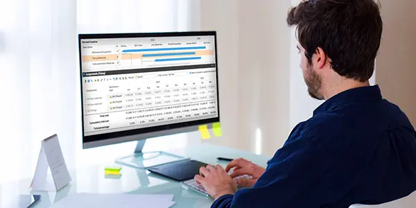 A worker monitoring a time-phased budget for a construction project on a software dashboard