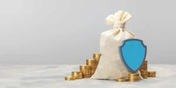 Stacked coins protected by a shield, representing the use of contingency budgets for risk management
