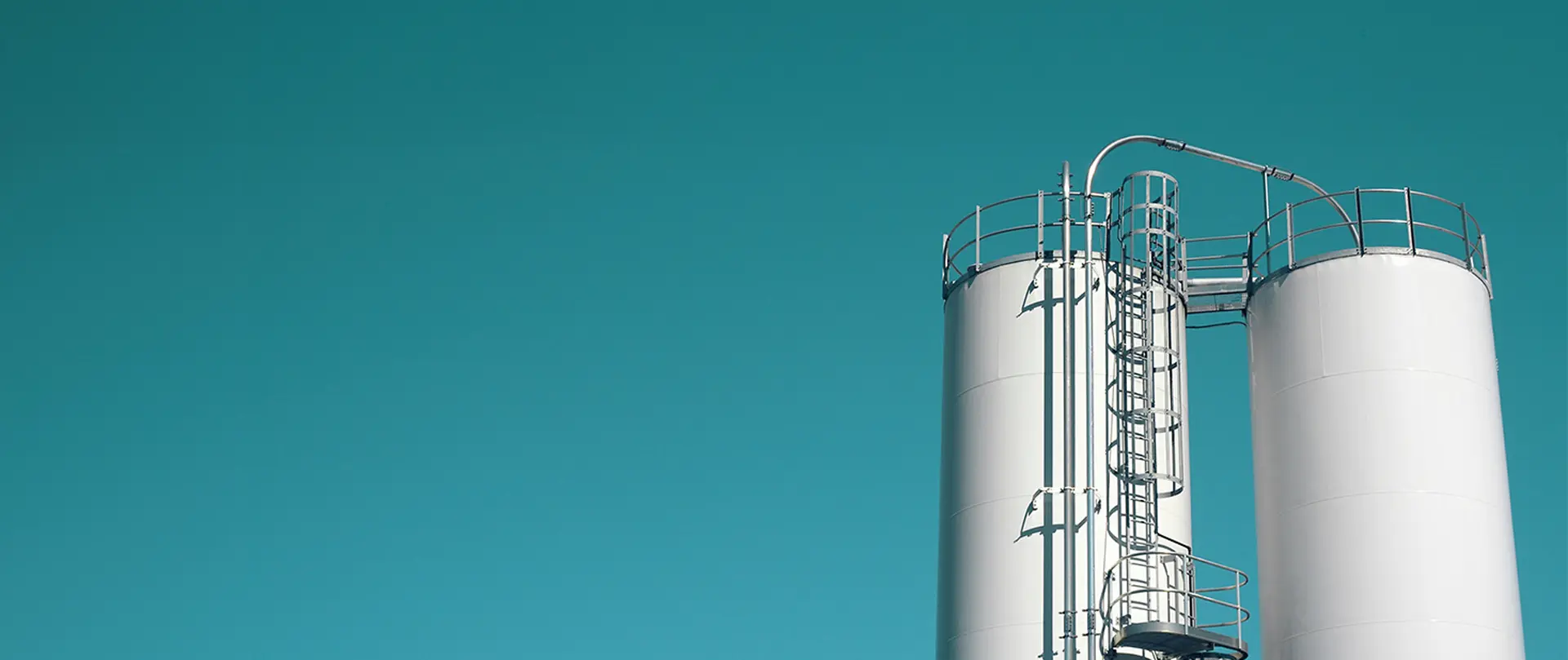 cylindrical industrial storage tanks against a blue sky