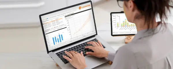 A professional analyzing cost benchmarks on a laptop.
