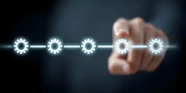 A hand picking a gear from a lineup, representing the project change control process in project management.